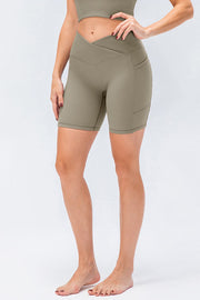 Cross-waist bike shorts in Matcha Green with side pockets.