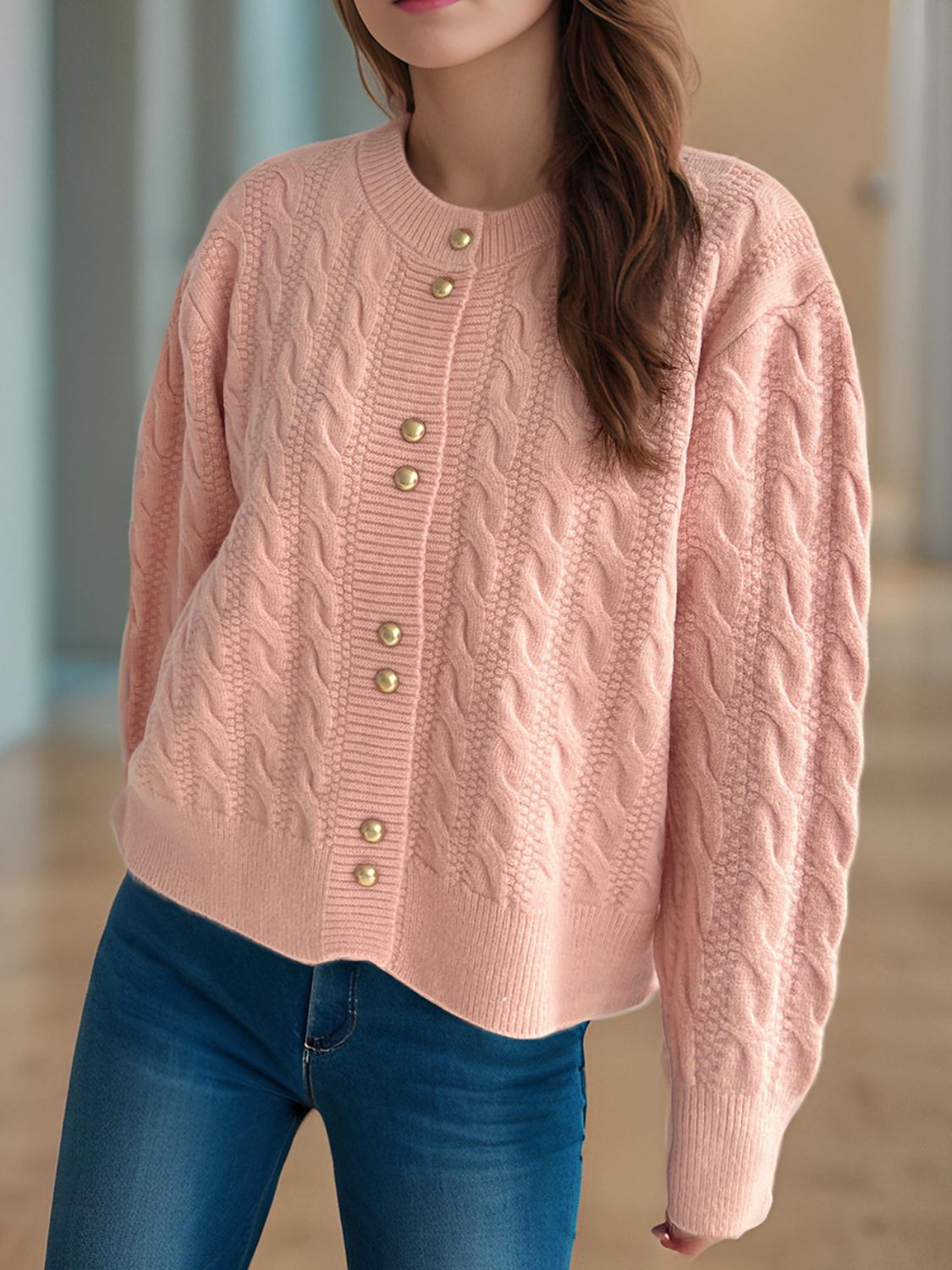 Dusty pink cable knit cardigan with puff sleeves and gold buttons.