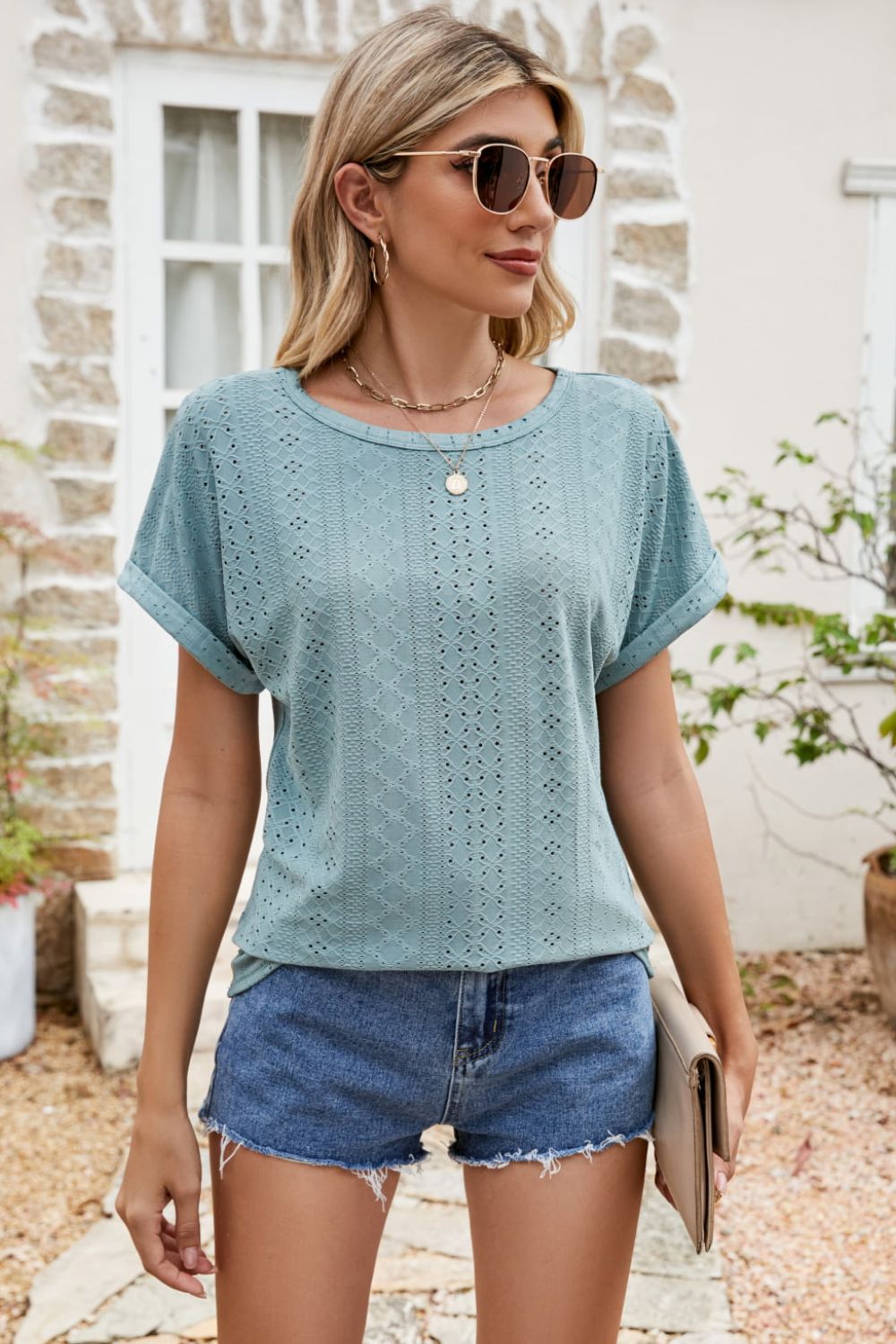 Teal perforated tee with crew neck and cuffed short sleeves.
