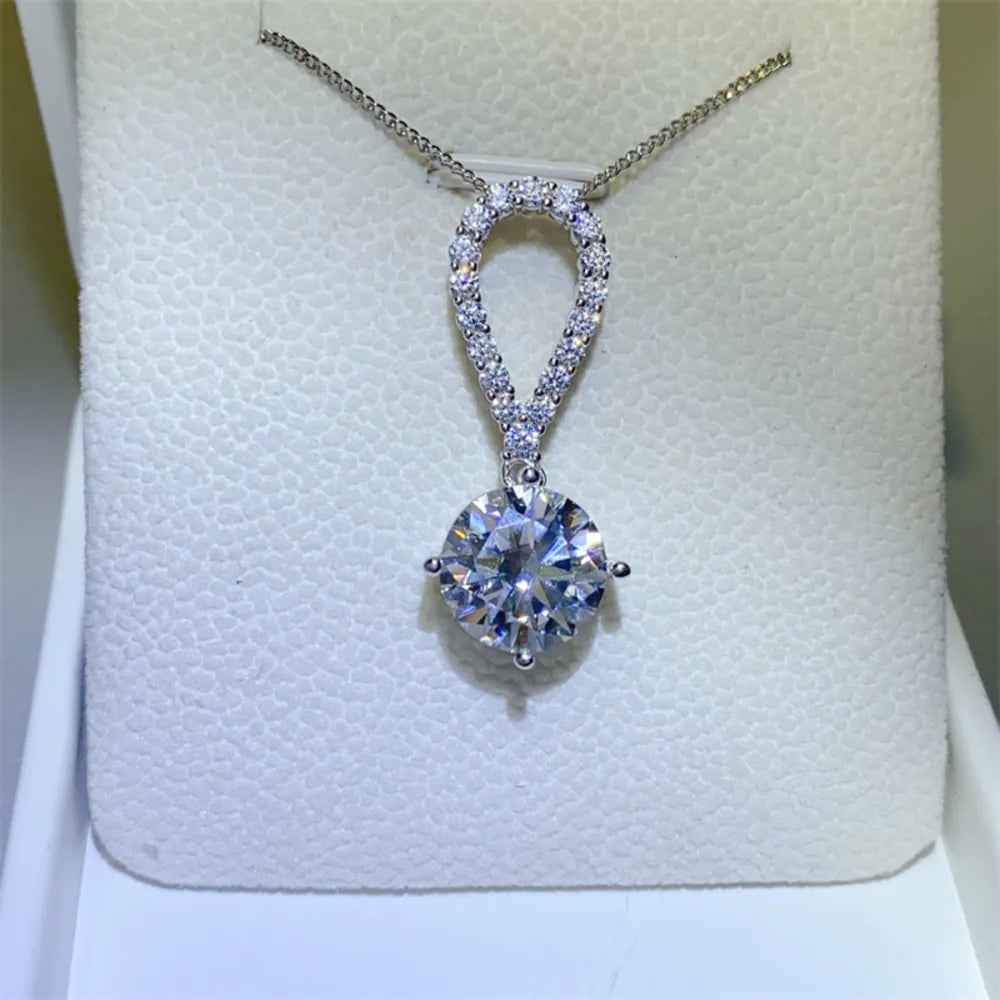 Silver pavé halo solitaire pendant necklace with a large round-cut diamond.