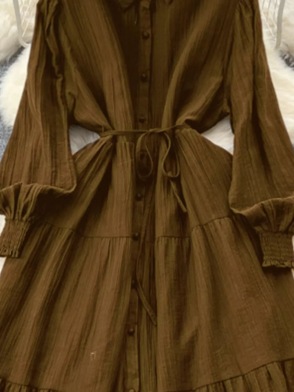 Textured tiered long sleeve dress in Olive Brown with button-down front and tie waist.