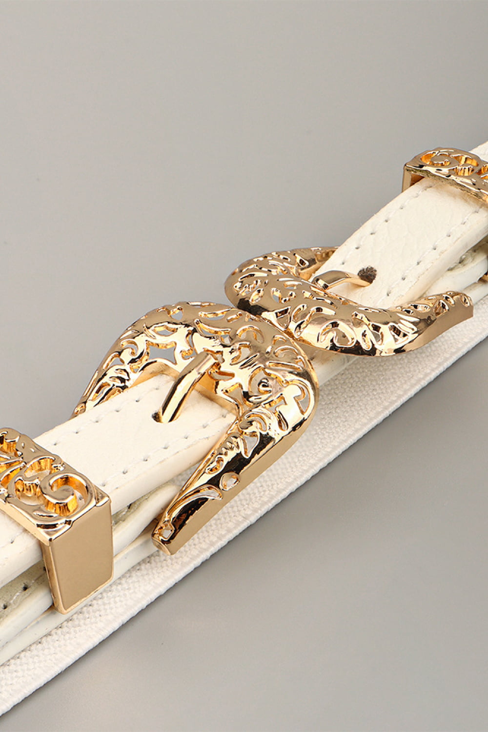 White elastic waist belt with ornate gold buckle detail