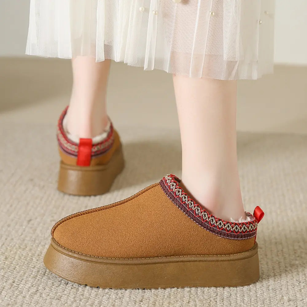 Camel shearling trim platform mules with red pull tab and patterned trim.