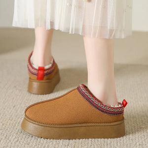 Camel shearling trim platform mules with red pull tab and patterned trim.