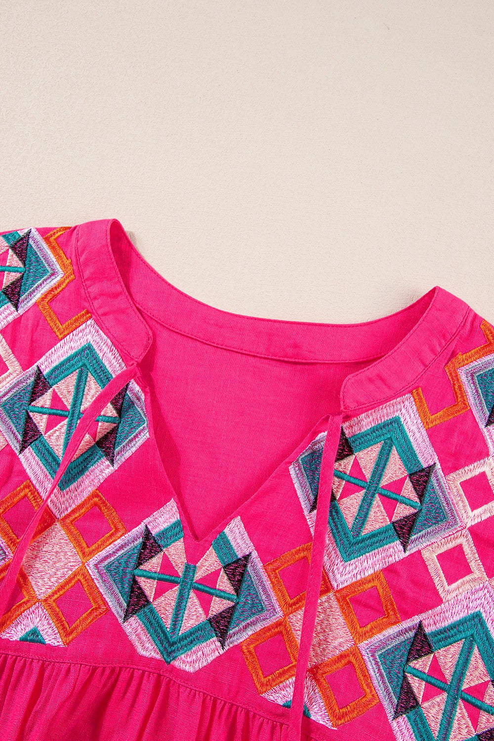 Strawberry embroidered yoke tie-neckline blouse with geometric pattern.