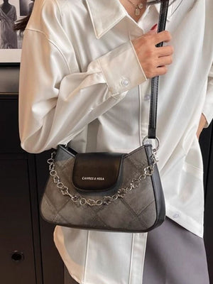 Textured leather shoulder bag with decorative chain strap and flap closure.