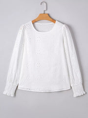 White cotton blouse with eyelet embroidery, ruffled cuffs, and puff sleeves.