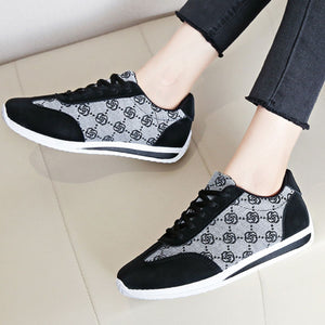 Black and grey patterned lace-up round toe sneakers with white soles.