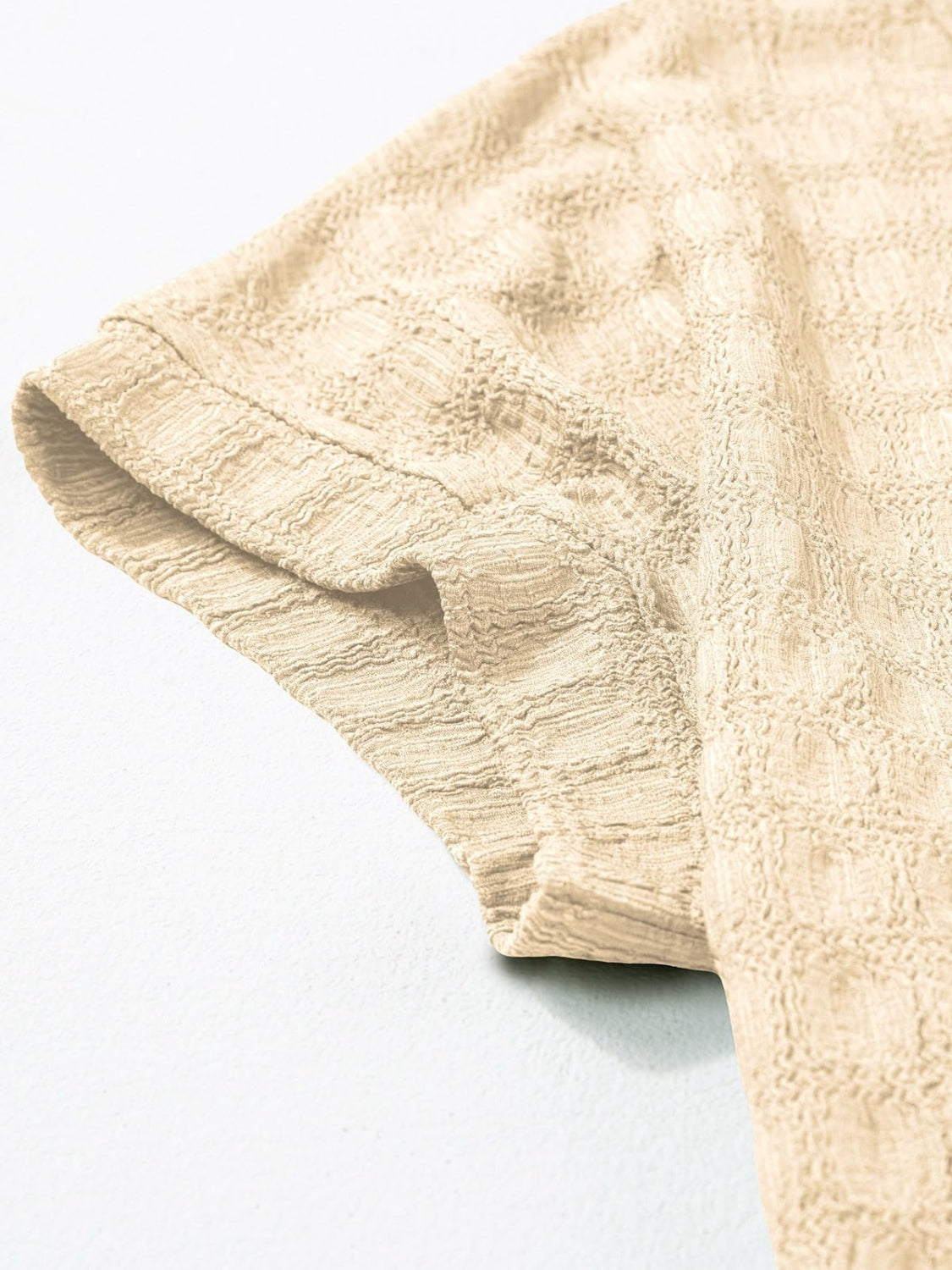 Tan woven texture cap-sleeve blouse with a textured grid pattern.