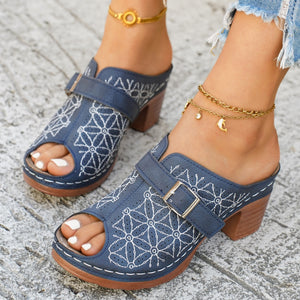 Blue block heel sandals with white floral embroidery and buckle detail.