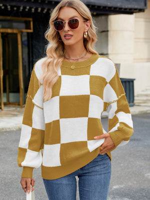 Checkerboard knit sweater in mustard and white with balloon sleeves and chain detail on shoulders.
