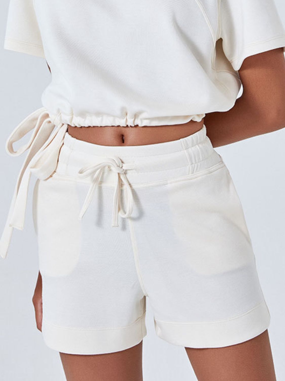 Cream drawstring pocket shorts with elastic waistband and cuffed hem