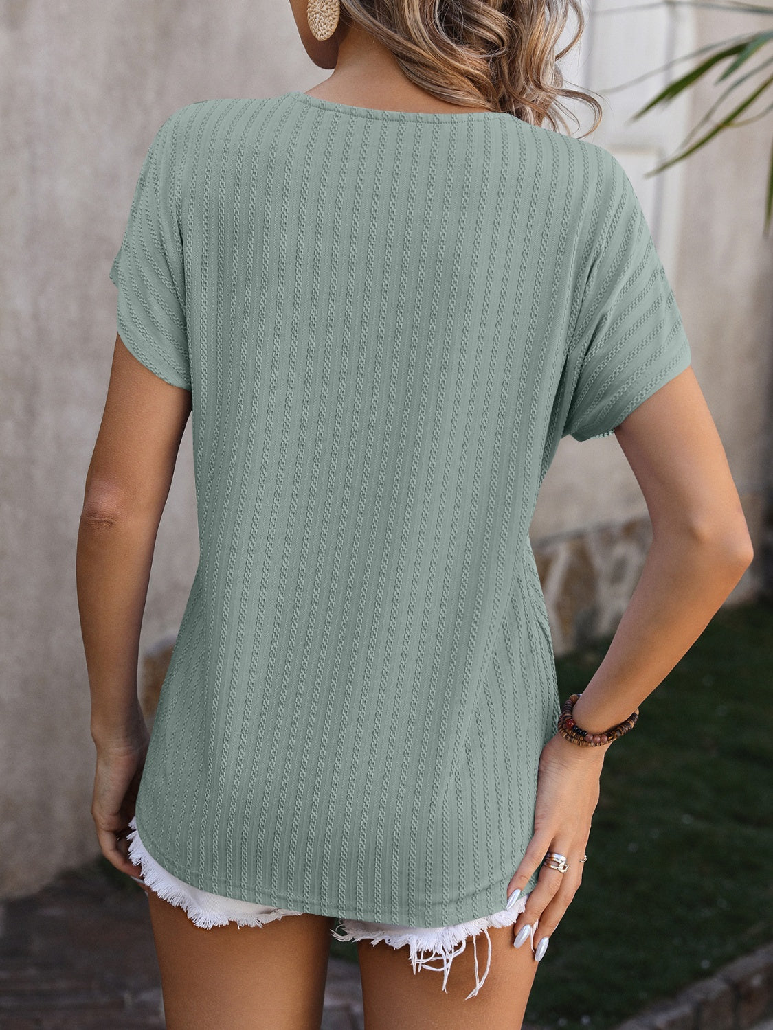Sage green textured tee with short sleeves and a V-neck, showing the back.