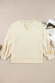 Gathered sleeve V-neck blouse in pastel yellow with contrast stitching.