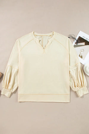 Gathered sleeve V-neck blouse in pastel yellow with contrast stitching.