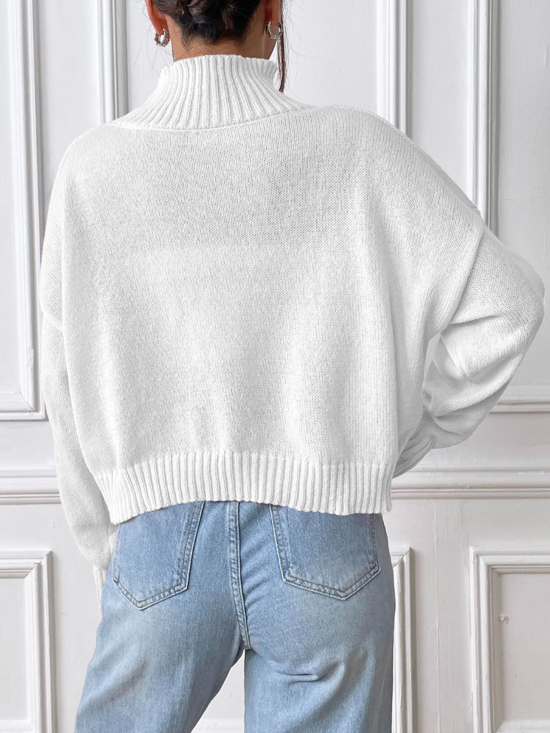 White ribbed turtleneck knit sweater with a cropped hem and relaxed fit.