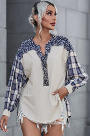 Beige mixed media blouse with floral yoke and plaid sleeves.