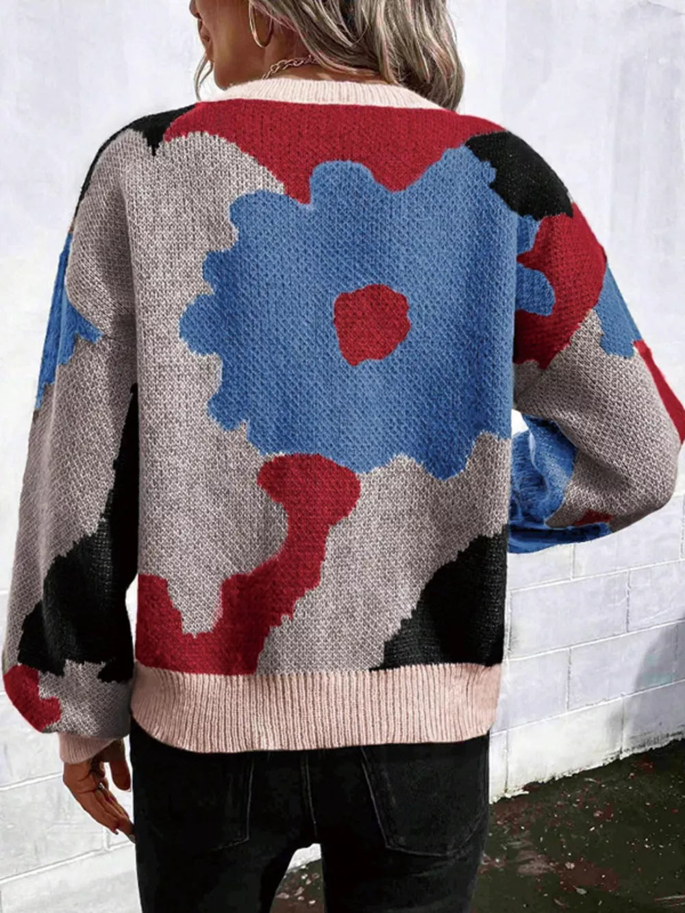 Abstract floral knit sweater with round neck in blue, red, black, and grey.