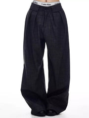 Men's dark grey wide-leg trousers with pleats and a textured fabric.