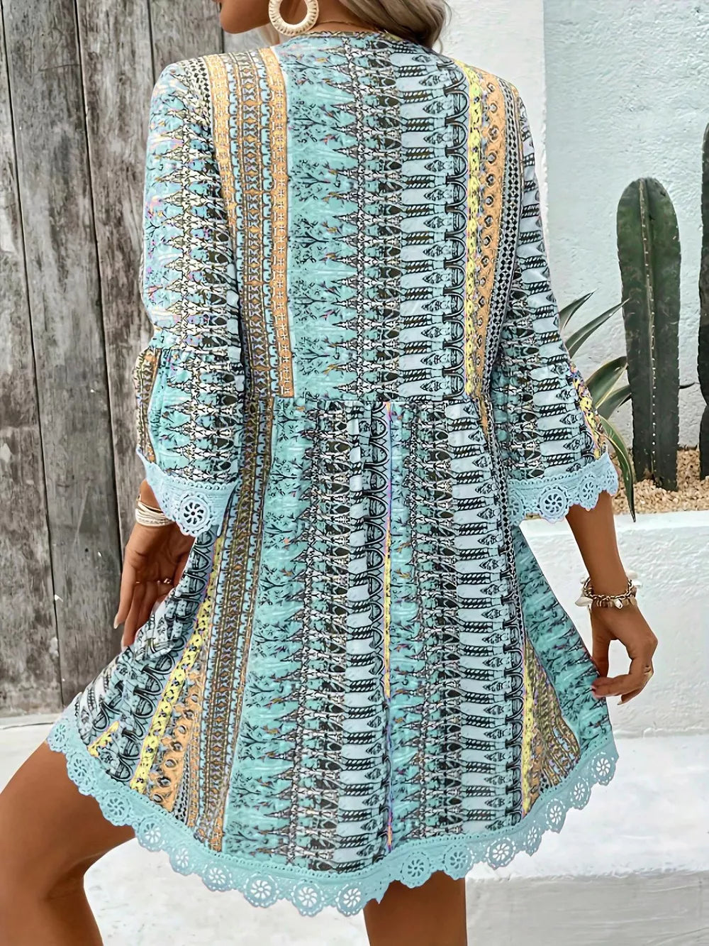 Bohemian printed v-neck dress with bell sleeves and lace trim in blue.