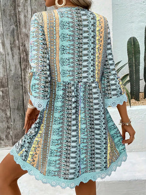 Bohemian printed v-neck dress with bell sleeves and lace trim in blue.