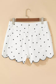 White polka dot chino shorts with scalloped hem and black trim.