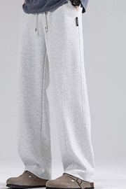Men's light gray loose fit sweatpants with drawstring waist and curved seam detail.
