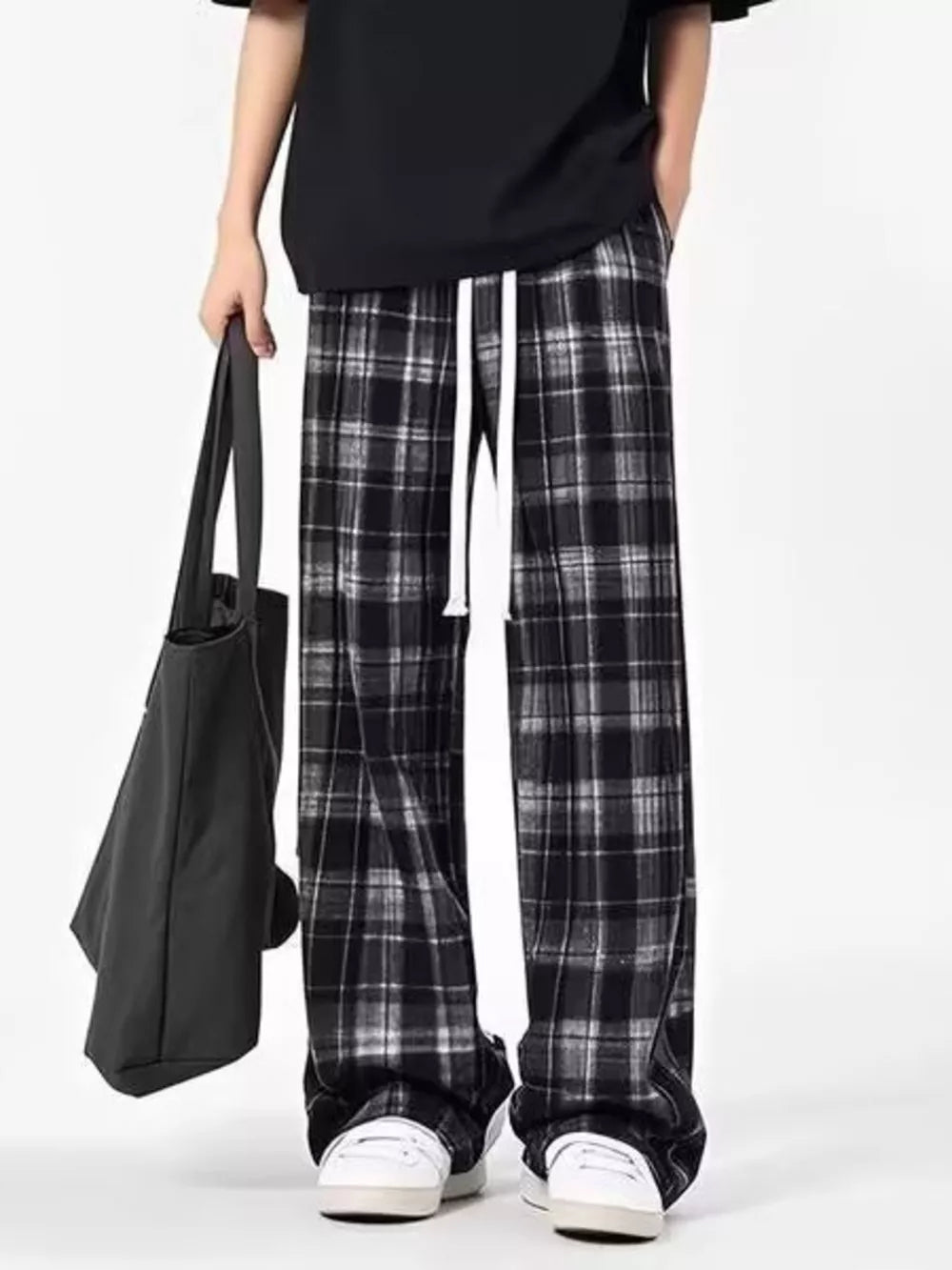 Plaid drawstring sweatpants in black and white with a relaxed fit.