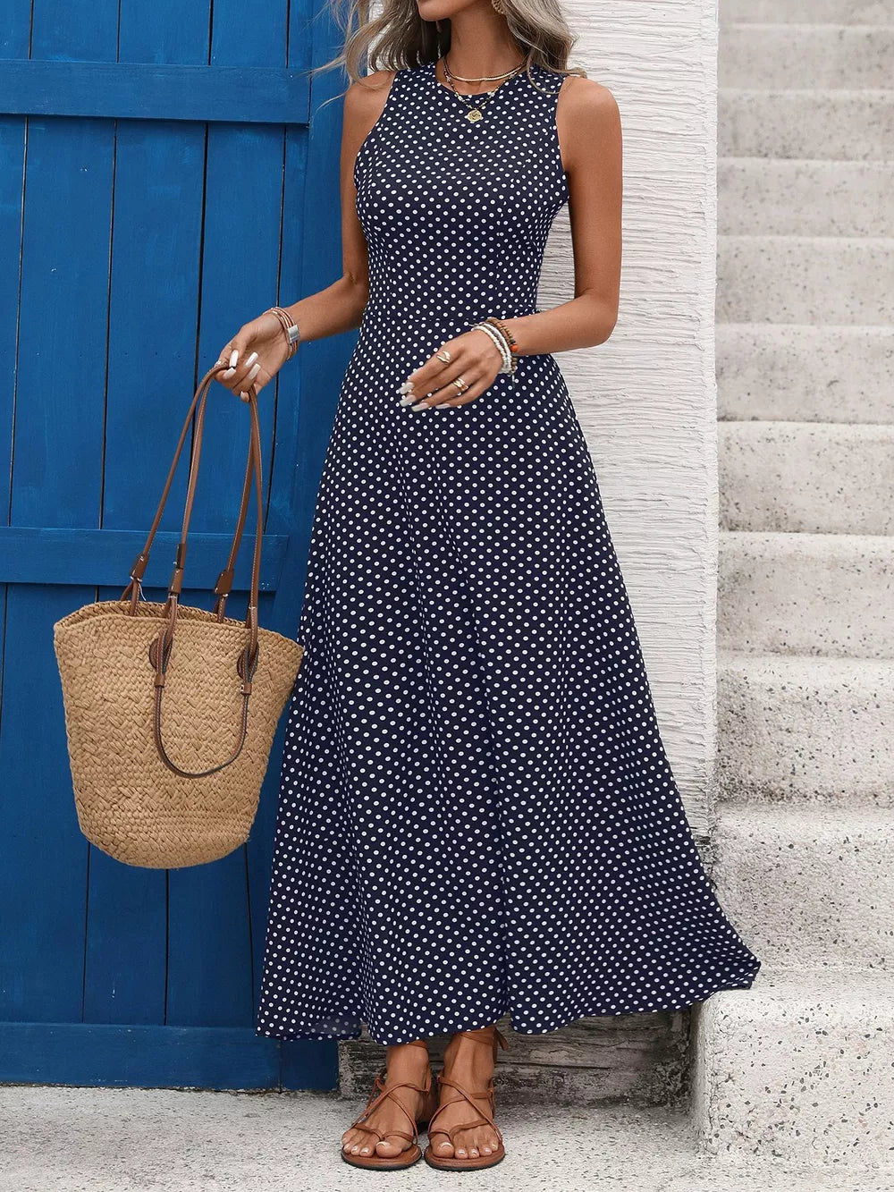 Dark blue polka dot maxi dress with a flattering silhouette and sleeveless design.