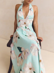 Elegant floral halter neck maxi dress in blue with a deep V-neck and a-line skirt.