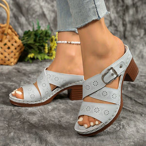 Gray laser-cut criss-cross block heel sandals with buckle detail.