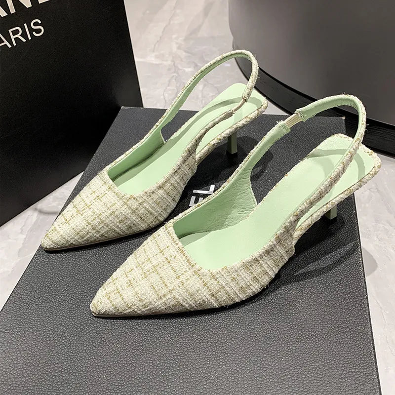 Textured tweed slingback kitten heels in light green with pointed toe and elastic strap.
