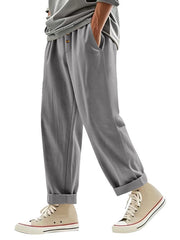 Men's grey loose fit sweatpants with drawstring waist and button detail.