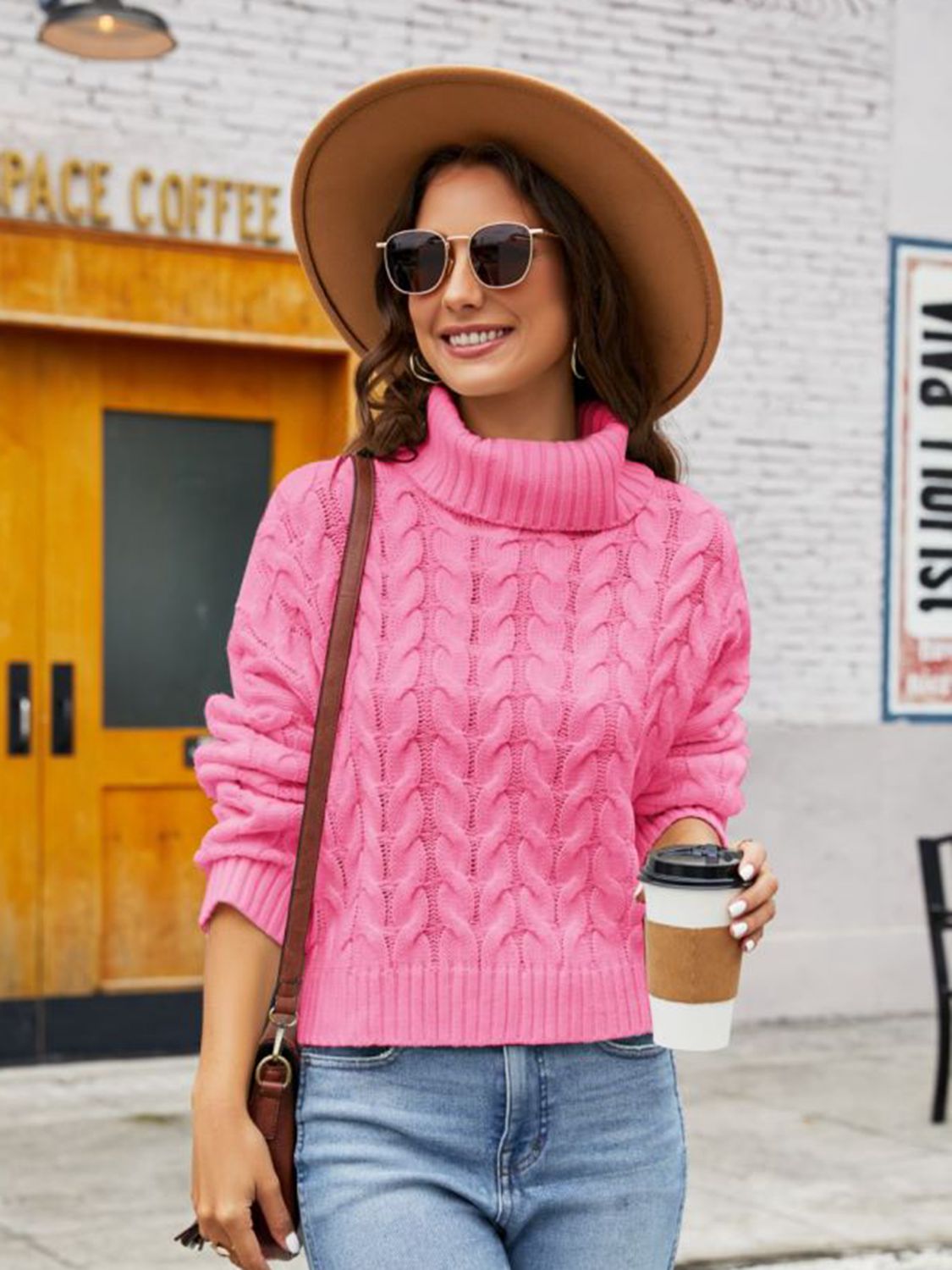 Pink cable-knit acrylic sweater with a chunky turtleneck, cropped length, and relaxed fit.
