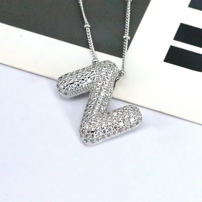 Pave initial pendant necklace with beaded chain, featuring a silver-tone alphabet pendant encrusted with clear stones.