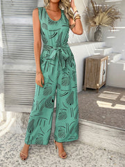 Turquoise abstract print wide-leg jumpsuit with tie waist and scoop neck.