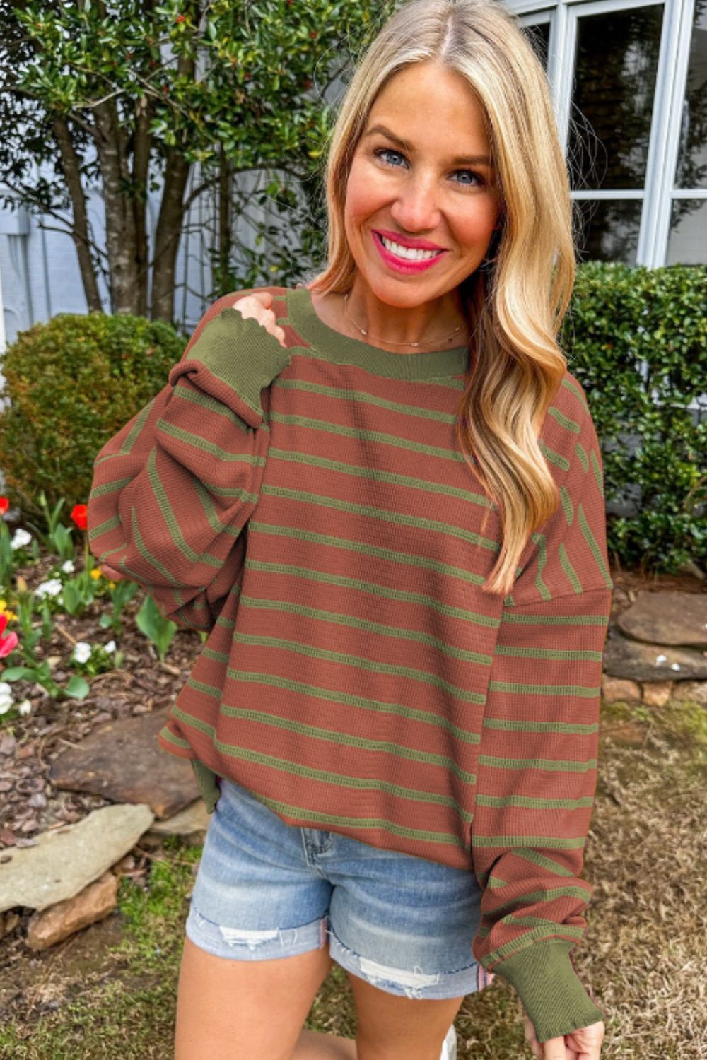 Brown waffle knit sweater with green stripes and contrast sleeves.