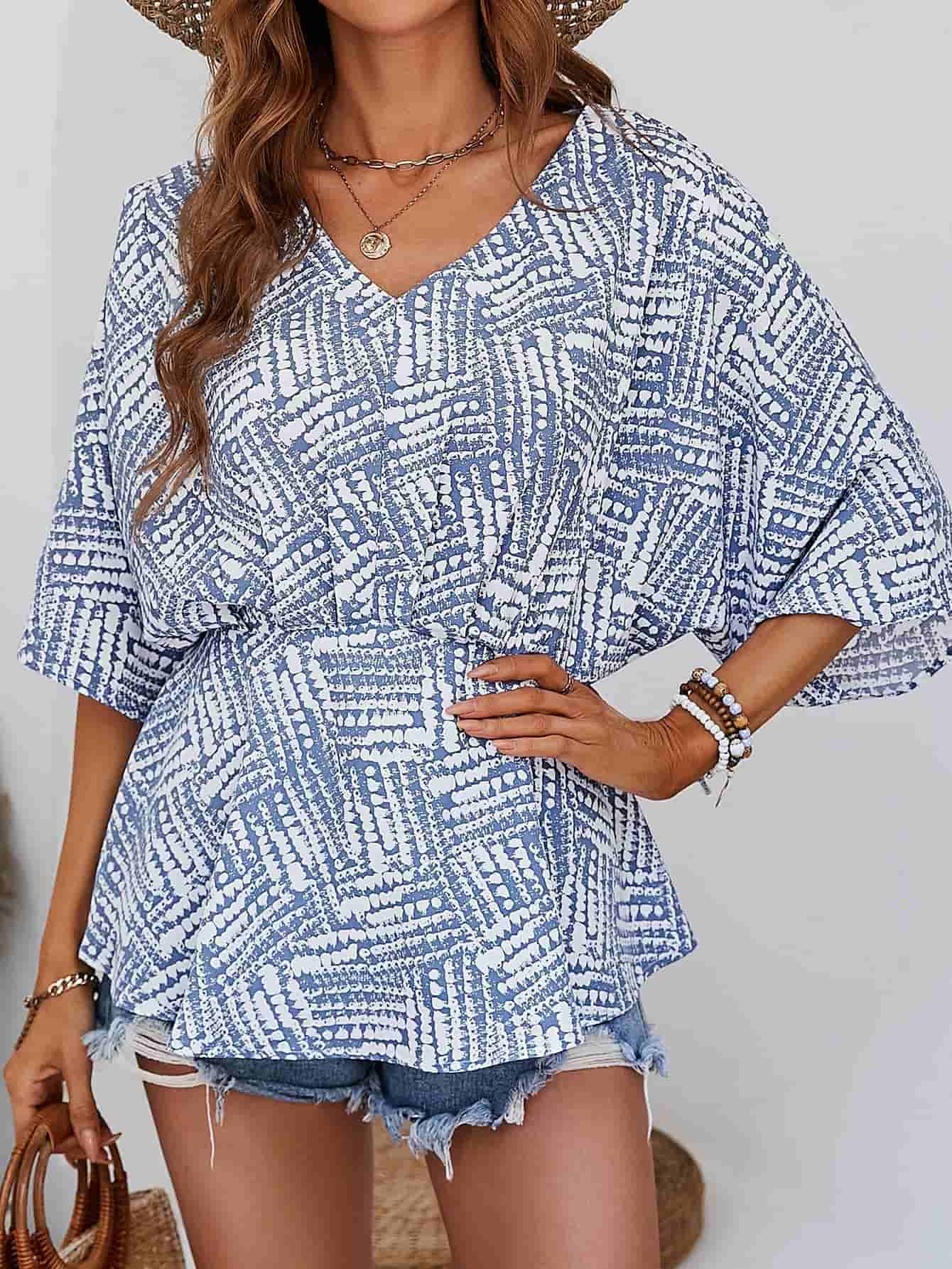 Light blue and white abstract print cinched waist blouse with V-neck and short sleeves.
