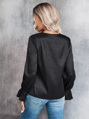 Black satin blouse with subtle animal print and ruffle cuffs