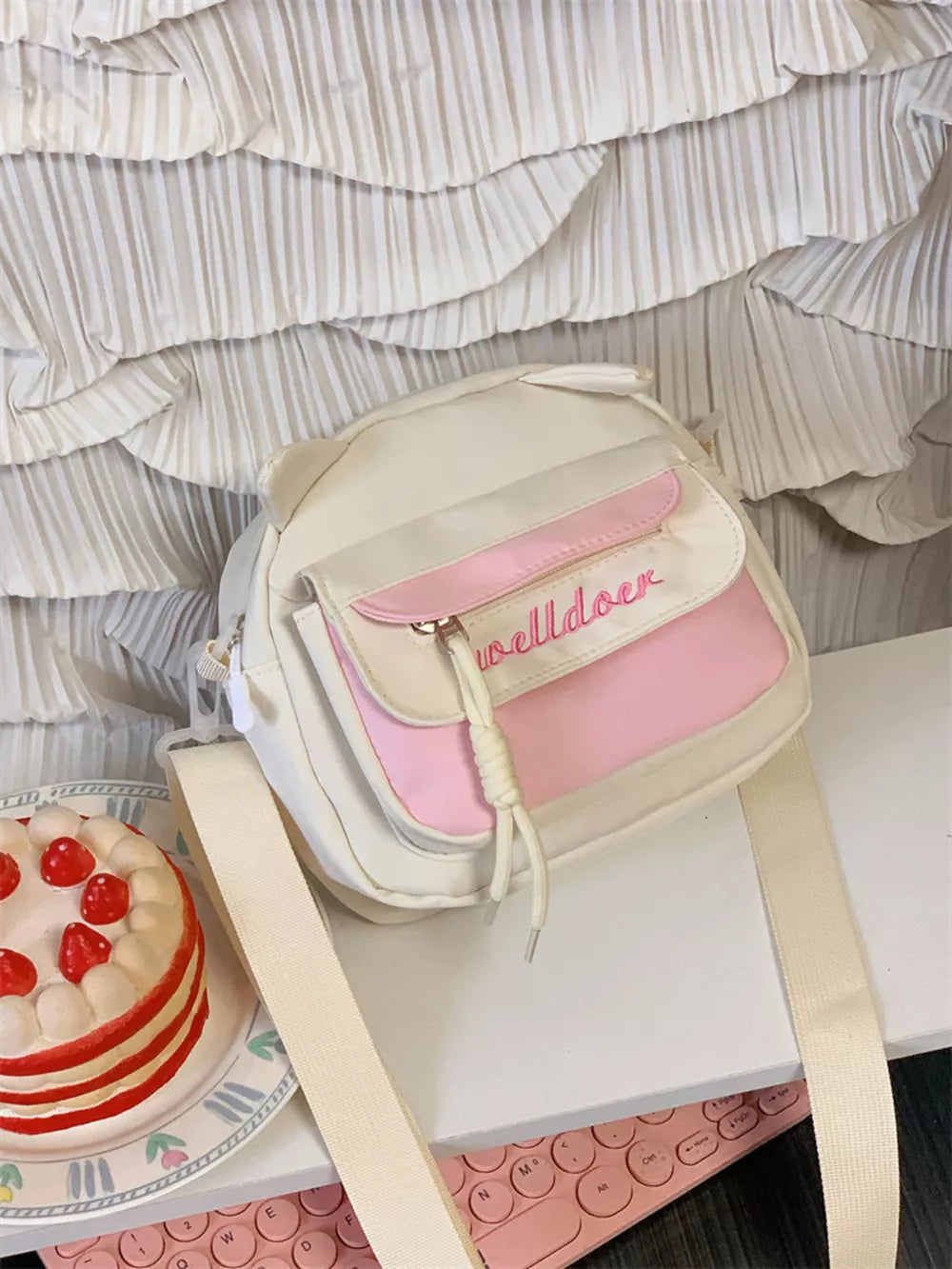 Playful mini crossbody bag in cream with pink accents and cat ears.