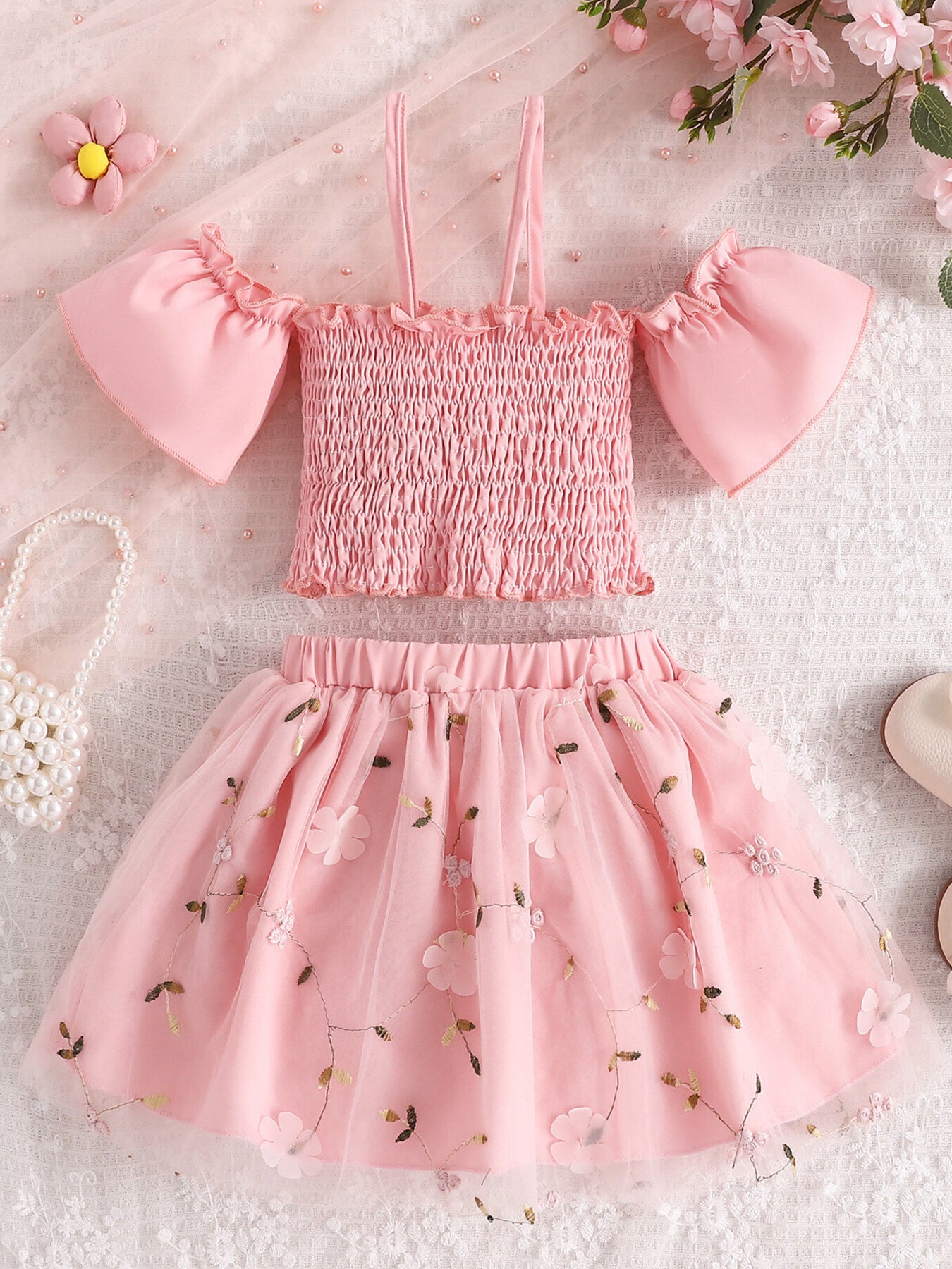 Pink smocked off-shoulder top with ruffled sleeves and floral embroidered tulle skirt set.