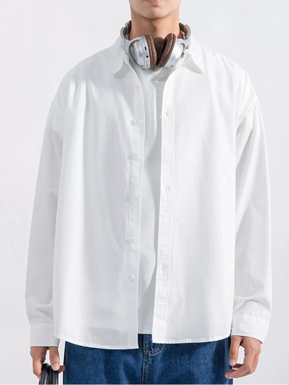 Men's white long sleeve button-up shirt with relaxed fit, styled casually.