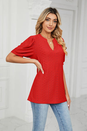Red perforated puff sleeve blouse with keyhole neckline and textured pattern.