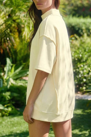 Yellow mock neck two-piece set with dropped shoulders and raw edge detail.