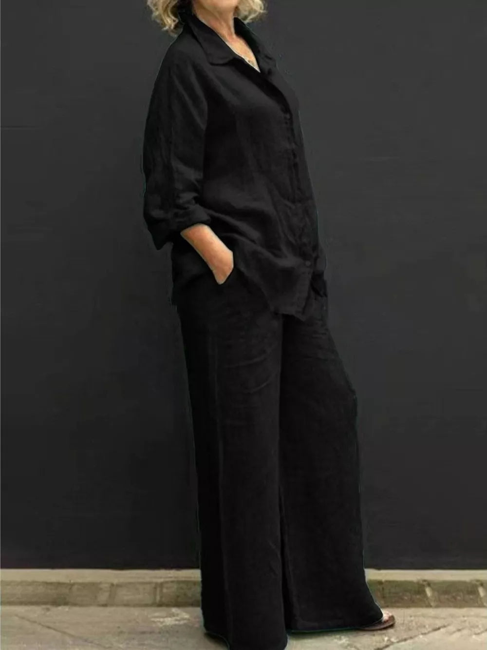 Black relaxed two-piece set with buttoned collared top and wide-leg pants.