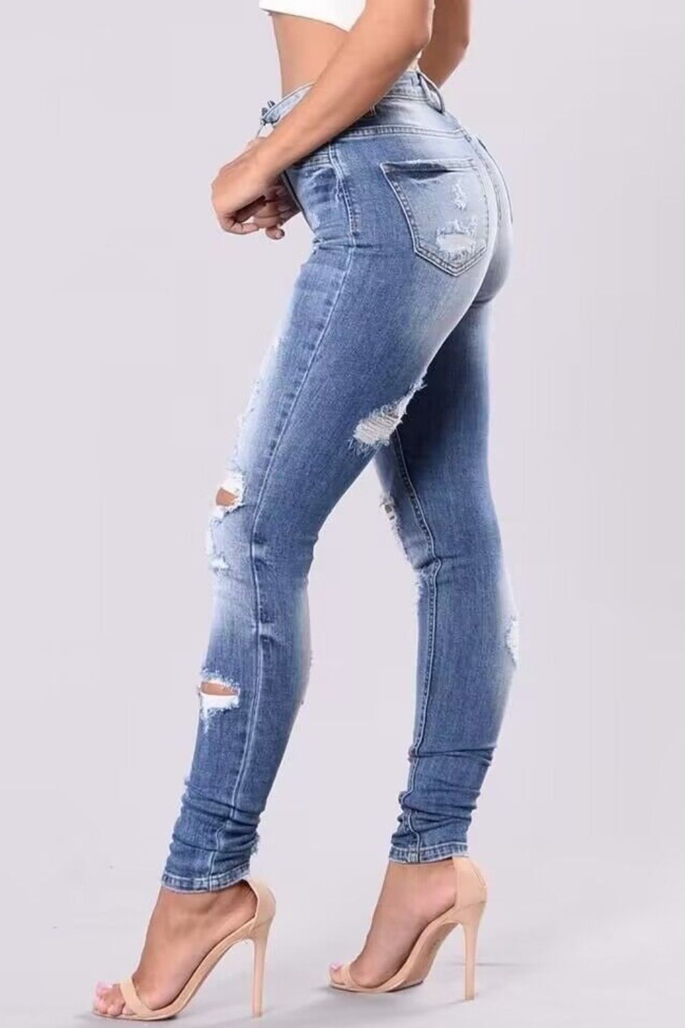 Light wash ripped knee skinny jeans with a sculpting fit.