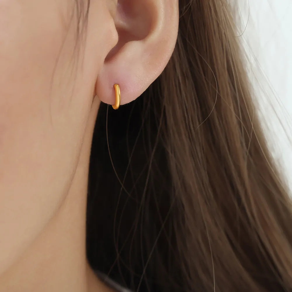 Minimalist gold vermeil huggie earrings, Style A, on earlobe