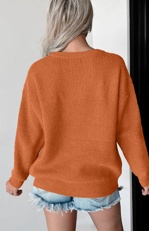 Terracotta knit sweater with ribbed texture and crew neck.