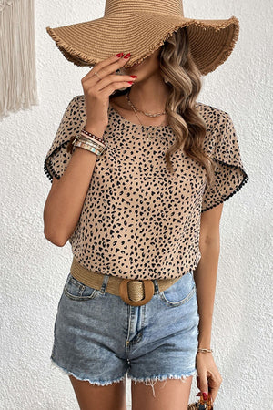 Leopard print blouse with pom-trim flutter sleeves and a round neckline.