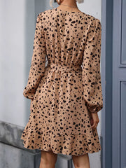 Leopard print mini dress with V-neck, long sleeves, belted waist, and ruffled hem.